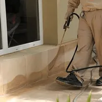 General pest control technician spraying exterior perimeter around a home in Reno, NV