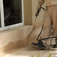 General pest control technician spraying exterior perimeter around a home in Reno, NV